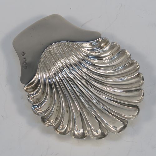 A very pretty Antique Victorian Sterling Silver butter shell dish, having a hand-chased scalloped body, a plain flat side handle, and all sitting on three ball feet. This beautiful antique silver butter shell was made by Horace Woodward of London in 1895. The dimensions of this fine hand-made antique silver butter dish shell are length 13 cms (5.25 inches), width 10 cms (4 inches), and it weighs approx. 69g (2.2 troy ounces).