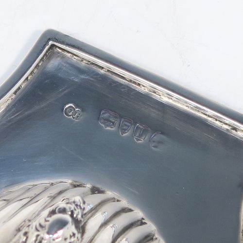 A very handsome Antique Victorian Sterling Silver butter shell dish, having a hand-chased scalloped body, a plain flat side handle, and all sitting on three cast shell feet. This elegant antique silver butter shell was made by Charles Boyton of London in 1886. The dimensions of this fine hand-made antique silver butter dish shell are length 13 cms (5.25 inches), width 10 cms (4 inches), and it weighs approx. 75g (2.4 troy ounces).
