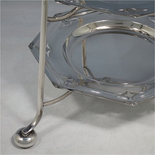 An Antique Edwardian pretty silver-plated cake stand, having three removable and graduated octagonal dishes with hand-pierced borders, all held in a wire-work frame with an oval carrying handle over scroll-work, and sitting on three bun feet. All made in ca. 1900. The dimensions of this fine hand-made antique silver-plated cake stand are height 45 cms (17.75 inches), width 30 cms (11.75 inchs), and the diameter of the dishes vary from 16.5 cms (6.5 inches) to 22 cms (8.6 inches).