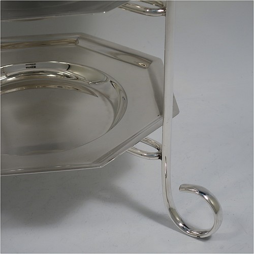 A very handsome Antique Edwardian silver plated three-tier cake stand, having a suite of three removable plain octagonal plates, sitting within a  frame with four scroll-work feet. Made in ca. 1910. The dimensions of this fine hand-made antique silver-plated cake stand are height 34 cms (13.3 inches), length at base 28 cms (11 inches), and width of plates 18 cms (7 inches).    