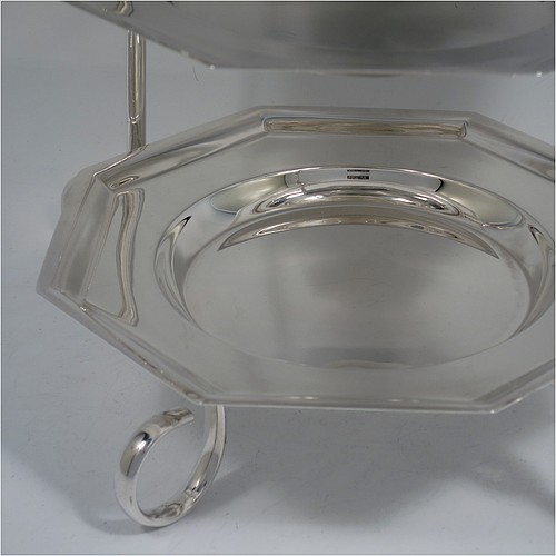 A very handsome Antique Edwardian silver plated three-tier cake stand, having a suite of three removable plain octagonal plates, sitting within a  frame with four scroll-work feet. Made in ca. 1910. The dimensions of this fine hand-made antique silver-plated cake stand are height 34 cms (13.3 inches), length at base 28 cms (11 inches), and width of plates 18 cms (7 inches).    