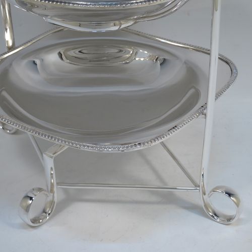 A pretty Antique Edwardian silver-plated cake stand, having two removable recessed plates with square bodies, rounded shoulders, and applied egg and dart borders. All sitting in a plain wire-work frame which in-turn sits on four scroll feet. All made in ca. 1910 by Daniel and Arter of Sheffield. The dimensions of this fine hand-made antique silver-plated cake stand are height 32 cms (12.5 inches), width 26 cms (10.25 inches), and the plates are 19 cms (7.5 inches) square.