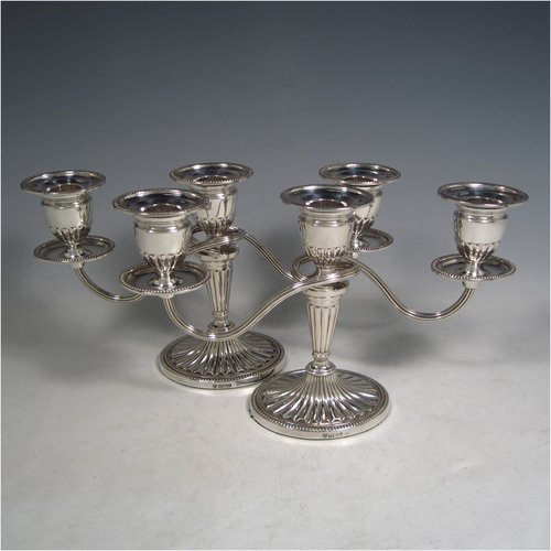 Sterling silver pair of small Neoclassical style three-light candelabra, having oval baluster bodies with fluted decoration and bead-edged borders, fixed arms with drip pans, and removable nozzles. Made by C. J. Vander of Sheffield in 1989. The dimensions of this fine hand-made pair of silver candelabra are height 16 cms (6.3 inches), and spread across arms 27.5 cms (10.75 inches).   