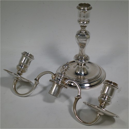 A very handsome Silver Plated cast pair of George II style two-light candelabra, having octagonal panelled and round baluster style bodies with reeded borders, removable scroll arms with two-lights and drip pans, and a central finial. Made in circa 1930. The dimensions of this fine hand-made pair of silver-plated candelabra are height 19 cms (7.5 inches), and spread across arms 25.5 cms (10 inches).
