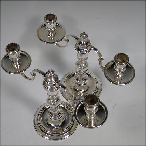 A very handsome Silver Plated cast pair of George II style two-light candelabra, having octagonal panelled and round baluster style bodies with reeded borders, removable scroll arms with two-lights and drip pans, and a central finial. Made in circa 1930. The dimensions of this fine hand-made pair of silver-plated candelabra are height 19 cms (7.5 inches), and spread across arms 25.5 cms (10 inches).