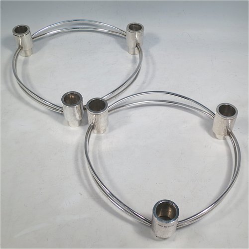 A Sterling Silver pair of very unusual Modernistic three-light candelabra, in a round style with bark-finish holders and removable nozzles, joined together with double wire-work sections. Made by Beatrice Midgley of Birmingham in 1973. The dimensions of this fine hand-made pair of silver candelabra are diameter 20 cms (8 inches), height 5 cms (2 inches), and with a total weight of approx. 840g (27 troy ounces).    