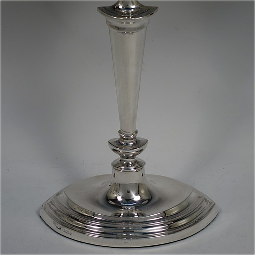 A very pretty Sterling Silver pair of candelabra in a Neoclassical boat-shaped style, having removable arms with three lights, plain and reed-banded columns with pointed oval bases, with plain scroll-shaped arms, capitals with reeded decoration, removable nozzles with drip pans, and reed-edged borders. Made by Mappin and Webb of Sheffield in 1938. The dimensions of this fine hand-made pair of silver candelabra are height 36.5 cms (14.3 inches), and spread across arms 32.5 cms (12.75 inches).