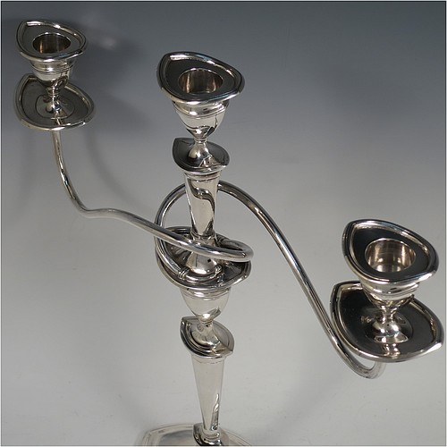 A very pretty Sterling Silver pair of candelabra in a Neoclassical boat-shaped style, having removable arms with three lights, plain and reed-banded columns with pointed oval bases, with plain scroll-shaped arms, capitals with reeded decoration, removable nozzles with drip pans, and reed-edged borders. Made by Mappin and Webb of Sheffield in 1938. The dimensions of this fine hand-made pair of silver candelabra are height 36.5 cms (14.3 inches), and spread across arms 32.5 cms (12.75 inches).