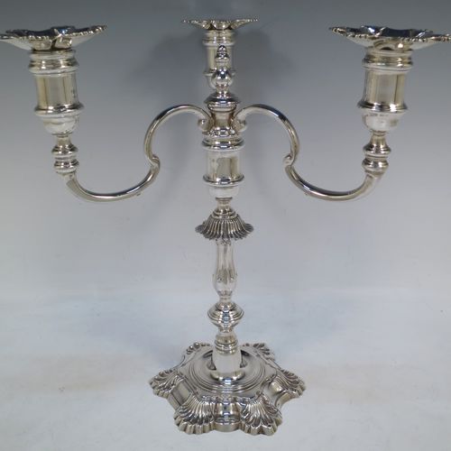 A handsome Sterling Silver cast single candelabrum in a George II style six-shell style, having removable three-light scroll arms with nozzles, and a central finial. Made in Birmingham in 1971. The dimensions of this fine hand-made silver three-light candelabrum are height 29 cms (11.5 inches), spread across arms 27 cms (10.75 inches), and with a total weight of approx. 1,300g (42 troy ounces). Please note that this candelabrum is all cast and not filled, so the whole weight is silver.   