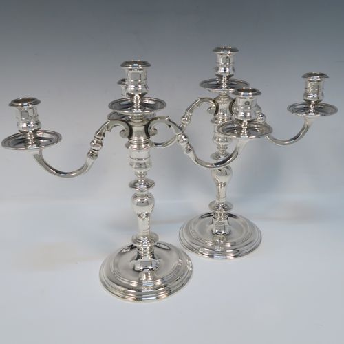 An elegant Sterling Silver cast pair of George I style three-light candelabra, having plain round and baluster style bodies, with removable scroll arms with nozzles and drip pans. This handsome pair of candelabra were made by Wakely and Wheeler of London in 1977. The dimensions of this fine hand-made pair of silver candelabra are height 26 cms (10.25 inches), spread across arms 29 cms (11.5 inches), and with a total weight of approx. 1,900g (61.3 troy ounces). Please note that these candelabra are not filled, so the whole weight is silver.   
