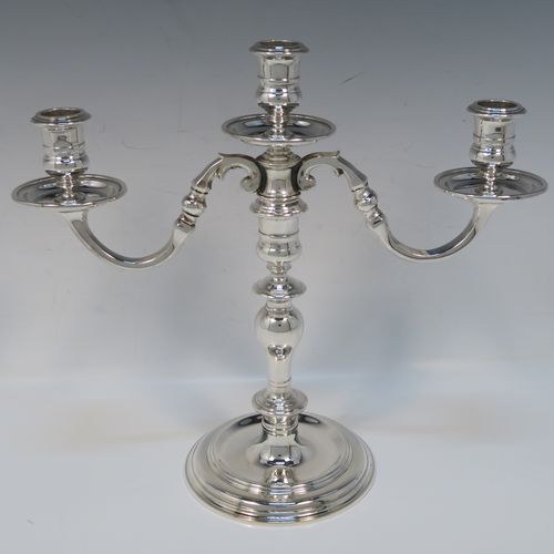 An elegant Sterling Silver cast pair of George I style three-light candelabra, having plain round and baluster style bodies, with removable scroll arms with nozzles and drip pans. This handsome pair of candelabra were made by Wakely and Wheeler of London in 1977. The dimensions of this fine hand-made pair of silver candelabra are height 26 cms (10.25 inches), spread across arms 29 cms (11.5 inches), and with a total weight of approx. 1,900g (61.3 troy ounces). Please note that these candelabra are not filled, so the whole weight is silver.