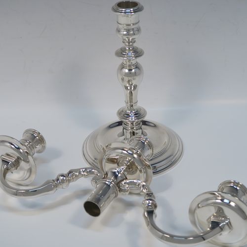 An elegant Sterling Silver cast pair of George I style three-light candelabra, having plain round and baluster style bodies, with removable scroll arms with nozzles and drip pans. This handsome pair of candelabra were made by Wakely and Wheeler of London in 1977. The dimensions of this fine hand-made pair of silver candelabra are height 26 cms (10.25 inches), spread across arms 29 cms (11.5 inches), and with a total weight of approx. 1,900g (61.3 troy ounces). Please note that these candelabra are not filled, so the whole weight is silver.