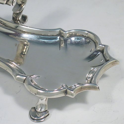 An Antique Georgian Sterling Silver candle scissor snuffer stand, having a plain shaped rectangular body, with an applied Chippendale border, a cast scroll handle with thumb-piece, and sitting on four cast hoof feet. Made by John Hyatt of London in 1761. The dimensions of this fine hand-made antique silver snuffer stand are length 18 cms (7 inches), height including handle 7 cms (2.75 inches), width 9 cms (3.5 inches), and it weighs approx. 217g (7 troy ounces).
