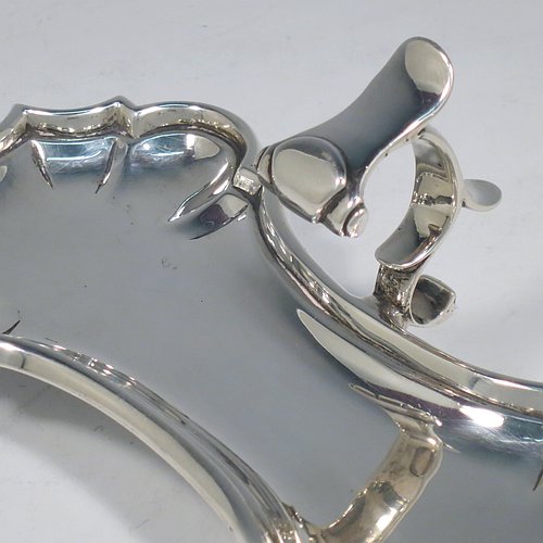 An Antique Georgian Sterling Silver candle scissor snuffer stand, having a plain shaped rectangular body, with an applied Chippendale border, a cast scroll handle with thumb-piece, and sitting on four cast hoof feet. Made by John Hyatt of London in 1761. The dimensions of this fine hand-made antique silver snuffer stand are length 18 cms (7 inches), height including handle 7 cms (2.75 inches), width 9 cms (3.5 inches), and it weighs approx. 217g (7 troy ounces).