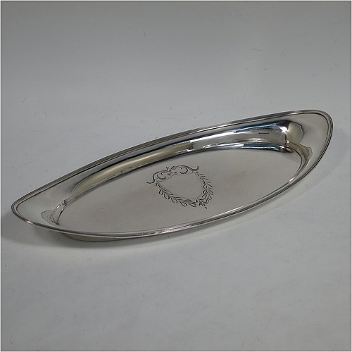 A handsome Antique Georgian Sterling Silver candle scissor snuffer stand or tray, having a plain elongated oval-shaped body with a central vacant cartouche surrounded by hand-engraved scroll-work and laurel leaves, an applied reeded border, and sitting on a flat base. Made by Soloman Hougham of London in 1800. The dimensions of this fine hand-made antique silver snuffer tray or stand are length 24 cms (9.5 inches), width 10.5 cms (4.25 inches), and it weighs approx. 127g (4 troy ounces).    