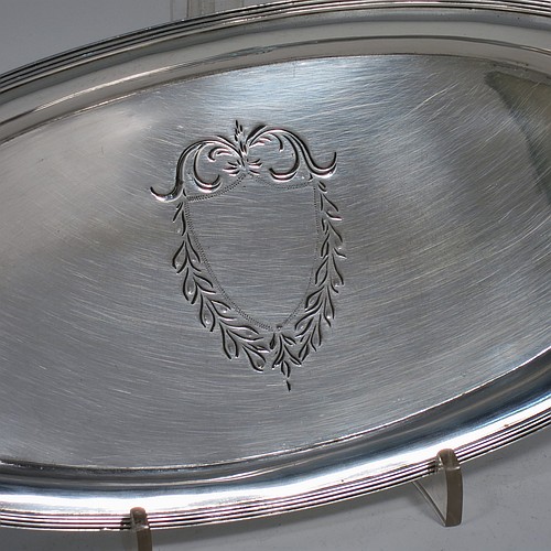 A handsome Antique Georgian Sterling Silver candle scissor snuffer stand or tray, having a plain elongated oval-shaped body with a central vacant cartouche surrounded by hand-engraved scroll-work and laurel leaves, an applied reeded border, and sitting on a flat base. Made by Soloman Hougham of London in 1800. The dimensions of this fine hand-made antique silver snuffer tray or stand are length 24 cms (9.5 inches), width 10.5 cms (4.25 inches), and it weighs approx. 127g (4 troy ounces).