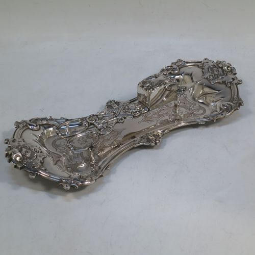 An Antique Georgian Old Sheffield Plated candle scissor snuffer stand and candle scissor snuffer, the stand having an applied floral & scroll border, a hand-chased ground with floral decoration, and sitting on a flat base with four stud feet. The scissor snuffer with matching decoration and all in original working condition. Made in ca. 1830. The dimensions of this fine hand-made antique Old Sheffield Plated snuffer stand and scissors are length 26 cms (10.25 inches), and width 11 cms (4.25 inches),  