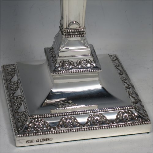 An Antique Victorian Sterling Silver pair of large table candlesticks, in a Neoclassical style, having square cross-section bodies with hand-chased swags and garland decoration, tapering columns, removable nozzles, and bead-edged borders. Made by J. K. Bembridge of Sheffield in 1886. The dimensions of these fine hand-made silver candlesticks are height 28 cms (11 inches), and 11 cms (4.25 inches) square at bases.   