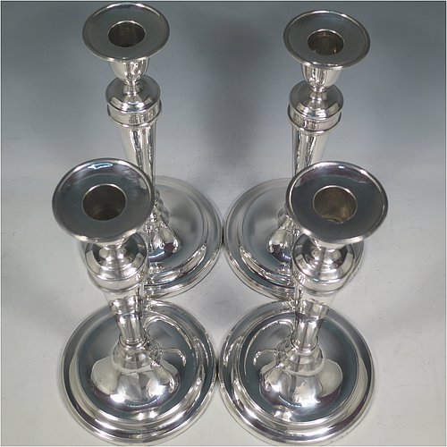 An Antique Georgian Sterling Silver set of four large table candlesticks, in a plain round style, having round bodies with reeded borders, tapering columns, and removable nozzles. Made by John Waterhouse & Co., of Sheffield in 1782. The dimensions of these fine hand-made antique silver candlesticks are height 27.5 cms (10.75 inches), and diameter at bases 14 cms (5.5 inches). Please note that these candlesticks are crested.   