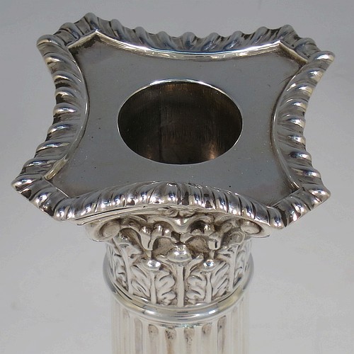 A very handsome and bold pair of Antique Victorian Sterling Silver table candlesticks, in a Neoclassical Corinthian style having square stepped bases, fluted columns, acanthus leaf capitals, removable nozzles, and gadroon borders. Made by Gibson and Langland of London in 1895. The dimensions of this fine hand-made pair of antique silver candlesticks are height 28 cms (11 inches), and their bases are 11.5 cms (4.5 inches) square.
