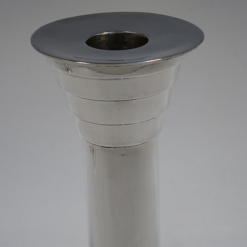 A very unusual and handsome Sterling Silver pair of Art Deco style candlesticks, having round stepped bases, plain round straight-sided columns, with stepped capitals and removable nozzles. Made by Walker and Hall of Sheffield in 1955. The dimensions of these fine hand-made Art Deco style silver table candlesticks are height 21 cms (8.25 inches), and diameter at base 12 cms (4.75 inches).
