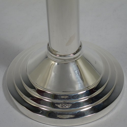 A very unusual and handsome Sterling Silver pair of Art Deco style candlesticks, having round stepped bases, plain round straight-sided columns, with stepped capitals and removable nozzles. Made by Walker and Hall of Sheffield in 1955. The dimensions of these fine hand-made Art Deco style silver table candlesticks are height 21 cms (8.25 inches), and diameter at base 12 cms (4.75 inches).