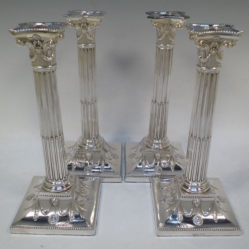 A very handsome set of four Antique Victorian Silver Plated table candlesticks, in a Neoclassical Corinthian style having square stepped bases with swag and lion-mask decoration, fluted columns, laurel leaf swag capitals, removable nozzles, and bead-edged borders. Made by Hawksworth Eyre and Co., of Sheffield in ca. 1880. The dimensions of this fine hand-made set of four antique silver-plated candlesticks are height 26 cms (10.25 inches), and their bases are 11 cms (4.3 inches) square.  