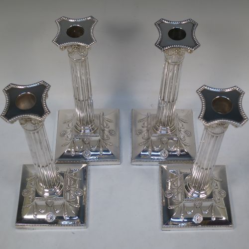 A very handsome set of four Antique Victorian Silver Plated table candlesticks, in a Neoclassical Corinthian style having square stepped bases with swag and lion-mask decoration, fluted columns, laurel leaf swag capitals, removable nozzles, and bead-edged borders. Made by Hawksworth Eyre and Co., of Sheffield in ca. 1880. The dimensions of this fine hand-made set of four antique silver-plated candlesticks are height 26 cms (10.25 inches), and their bases are 11 cms (4.3 inches) square.