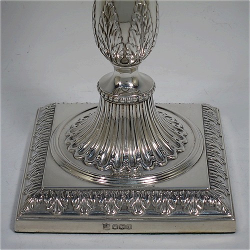 A very pretty set of four Sterling Silver candlesticks in a Neoclassical style, having round baluster bodies with hand-chased anthemion leaf and fluted decoration, with anthemion leaf-edged borders, sitting on square bases with matching decoration, and original removable nozzles. This beautiful set of silver candlesticks were made by Thomas Bradbury of Sheffield in 1921. The dimensions of these fine hand-made silver candlesticks are height 28 cms (11 inches), base 12 cms (4.75 inches) square.
