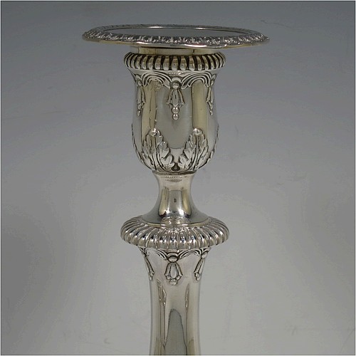 A very pretty set of four Sterling Silver candlesticks in a Neoclassical style, having round baluster bodies with hand-chased anthemion leaf and fluted decoration, with anthemion leaf-edged borders, sitting on square bases with matching decoration, and original removable nozzles. This beautiful set of silver candlesticks were made by Thomas Bradbury of Sheffield in 1921. The dimensions of these fine hand-made silver candlesticks are height 28 cms (11 inches), base 12 cms (4.75 inches) square.