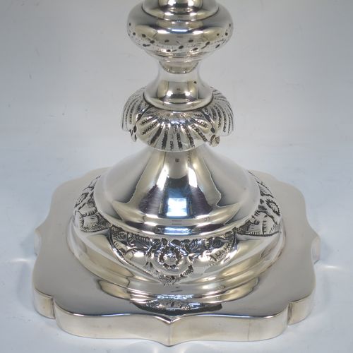 A very bold antique Sterling Silver pair of Sabbath candlesticks, having round baluster bodies with hand-chased floral decoration, shaped square bases, and removable nozzles. Made by Morris Salkind of London in 1919. The dimensions of these fine hand-made antique silver Sabbath candlesticks are height 36 cms (14 inches), base 14 cms (5.5 inches) square, and they weigh a total of approx. 1,008g (32.5 troy ounces). Please note that these candlesticks are not filled.