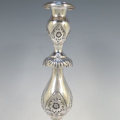 A very bold antique Sterling Silver pair of Sabbath candlesticks, having round baluster bodies with hand-chased floral decoration, shaped square bases, and removable nozzles. Made by Morris Salkind of London in 1919. The dimensions of these fine hand-made antique silver Sabbath candlesticks are height 36 cms (14 inches), base 14 cms (5.5 inches) square, and they weigh a total of approx. 1,008g (32.5 troy ounces). Please note that these candlesticks are not filled.