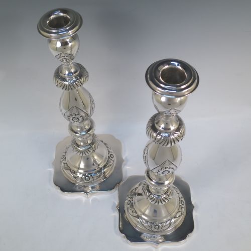 A very bold antique Sterling Silver pair of Sabbath candlesticks, having round baluster bodies with hand-chased floral decoration, shaped square bases, and removable nozzles. Made by Morris Salkind of London in 1919. The dimensions of these fine hand-made antique silver Sabbath candlesticks are height 36 cms (14 inches), base 14 cms (5.5 inches) square, and they weigh a total of approx. 1,008g (32.5 troy ounces). Please note that these candlesticks are not filled.