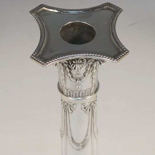 A very pretty pair of Antique Sterling Silver table candlesticks, in a Neoclassical Corinthian style having square bases with hand-chased swags, ribbons and bows, and bead-edged borders, with original removable nozzles. This beautiful pair of antique silver candlesticks were made by Thomas Bradbury and Sons of Sheffield in 1918. The dimensions of this fine hand-made pair antique silver candlesticks are height 31 cms (12.25 inches), and their bases are 12.5 cms (5 inches) square.