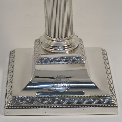 A very pretty pair of Antique Georgian Sterling Silver table candlesticks, in a Neoclassical Corinthian style having square bases with fluted columns, leaf tendril and double-bead border decoration, the capitals with swags and bead-work decoration on the removable nozzles. These beautiful antique silver candlesticks were made John Waterhouse of Sheffield in 1781. The dimensions of this fine hand-made pair of antique silver table candlesticks are height 29 cms (11.5 inches), and their bases are 12 cms (4.75 inches) square. Please note that these items are crested on the bases.