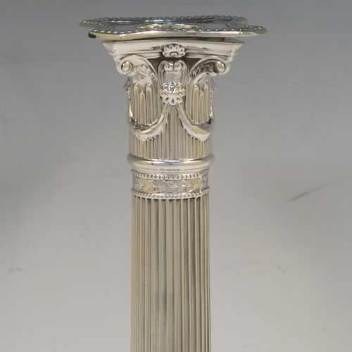 A very pretty pair of Antique Georgian Sterling Silver table candlesticks, in a Neoclassical Corinthian style having square bases with fluted columns, leaf tendril and double-bead border decoration, the capitals with swags and bead-work decoration on the removable nozzles. These beautiful antique silver candlesticks were made John Waterhouse of Sheffield in 1781. The dimensions of this fine hand-made pair of antique silver table candlesticks are height 29 cms (11.5 inches), and their bases are 12 cms (4.75 inches) square. Please note that these items are crested on the bases.