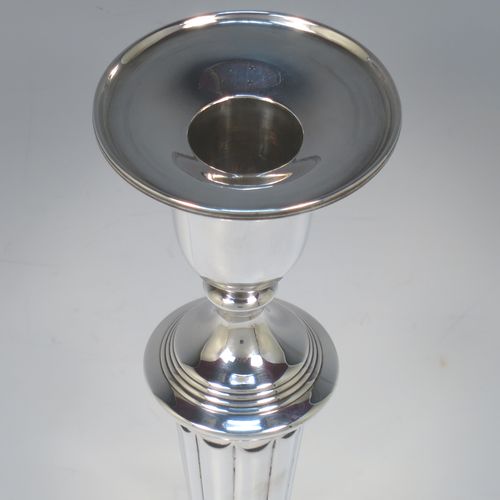 A very handsome pair of Antique Georgian Sterling Silver large table candlesticks in a Neoclassical style, having round bodies with hand-chased reeded borders, tapering columns with hand-chased fluting, and original removable nozzles. Made by John Green and Son Ltd., of Sheffield in 1796. The dimensions of this fine hand-made pair of antique silver candlesticks are height 30 cms (11.75 inches), and diameter at bases 13.5 cms (5.3 inches).   