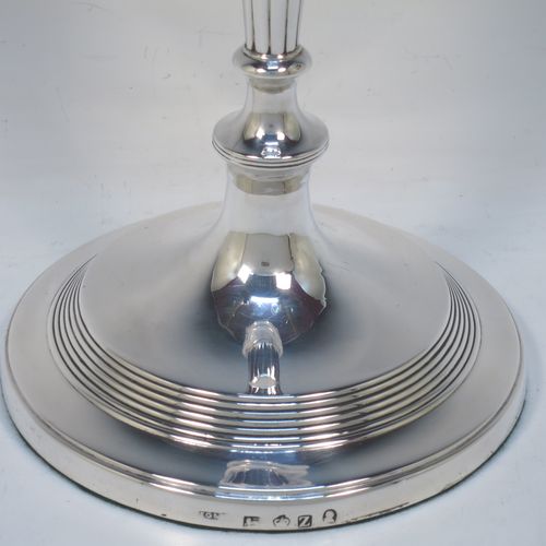 A very handsome pair of Antique Georgian Sterling Silver large table candlesticks in a Neoclassical style, having round bodies with hand-chased reeded borders, tapering columns with hand-chased fluting, and original removable nozzles. Made by John Green and Son Ltd., of Sheffield in 1796. The dimensions of this fine hand-made pair of antique silver candlesticks are height 30 cms (11.75 inches), and diameter at bases 13.5 cms (5.3 inches).   