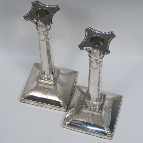 A very pretty pair of Antique Victorian Sterling Silver table candlesticks, in a Neoclassical Corinthian style having square bases with swags, ribbon and bows, and bead-work decoration, and removable nozzles. These beautiful silver candlesticks were made by Thomas Bradbury of London in 1897. The dimensions of this fine hand-made pair of antique silver candlesticks are height 23.5 cms (9.25 inches), and their bases are 11 cms (4.25 inches) square.