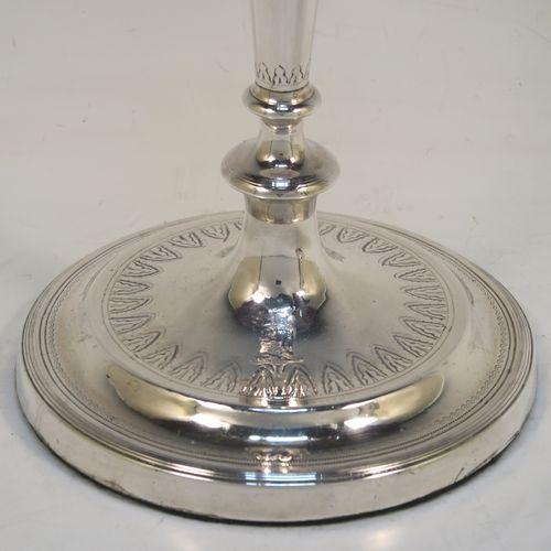 A very elegant pair of Antique Georgian Sterling Silver candlesticks, having round bodies with tapering sides, hand-chased bands of floral decoration, and reeded borders with original removable nozzles. These handsome antique silver table candlesticks were made by John Parsons and Co., of Sheffield in 1792. The dimensions of these fine hand-made antique Georgian silver candlesticks are height 27 cms (10.5 inches), and diameter of bases are 13 cms (5 inches) diameter.