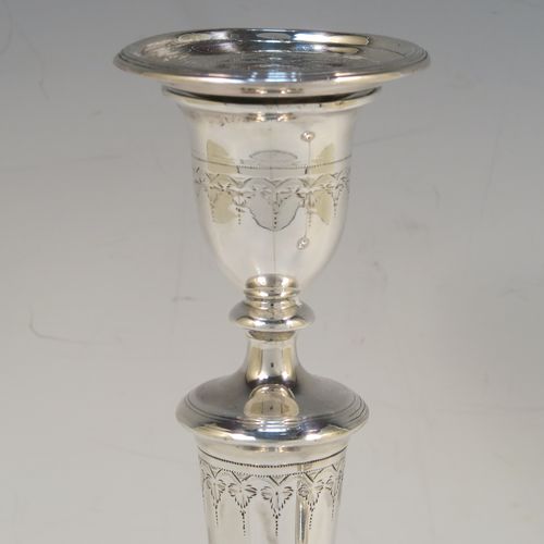 A very elegant pair of Antique Georgian Sterling Silver candlesticks, having round bodies with tapering sides, hand-chased bands of floral decoration, and reeded borders with original removable nozzles. These handsome antique silver table candlesticks were made by John Parsons and Co., of Sheffield in 1792. The dimensions of these fine hand-made antique Georgian silver candlesticks are height 27 cms (10.5 inches), and diameter of bases are 13 cms (5 inches) diameter.