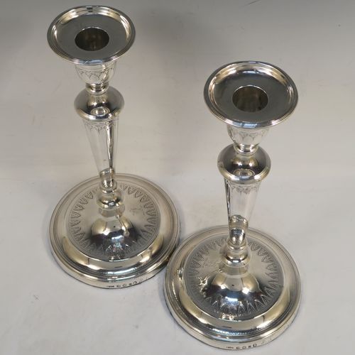 A very elegant pair of Antique Georgian Sterling Silver candlesticks, having round bodies with tapering sides, hand-chased bands of floral decoration, and reeded borders with original removable nozzles. These handsome antique silver table candlesticks were made by John Parsons and Co., of Sheffield in 1792. The dimensions of these fine hand-made antique Georgian silver candlesticks are height 27 cms (10.5 inches), and diameter of bases are 13 cms (5 inches) diameter.