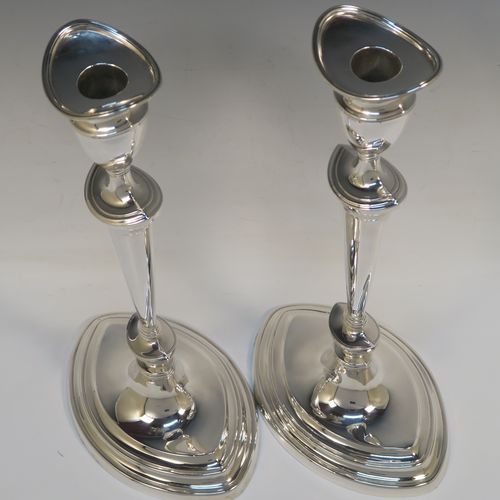 A very handsome pair of Antique Edwardian Sterling Silver candlesticks, having neoclassical plain oval boat-shaped bodies with reeded borders and tapering columns, and original removable nozzles. These elegant antique silver candlesticks were made by Thomas Bradbury of Sheffield in 1903. The dimensions of these fine hand-made antique silver candlesticks are height 30.5 cms (12 inches), and the bases are 17 cms (6.75 inches) long.