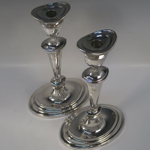 A very handsome and large pair of Sterling Silver candlesticks, having neoclassical plain oval boat-shaped bodies with reeded borders and tapering columns, and original removable nozzles. These elegant silver candlesticks were made by D. J. Silver of London in 1965. The dimensions of these fine hand-made silver candlesticks are height 30.5 cms (12 inches), and the bases are 16.5 cms (6.5 inches) long.   