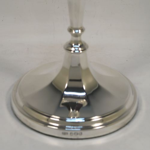 A handsome Sterling Silver pair of candlesticks, having round and octagonal panelled style bodies, with reeded borders, and removable nozzles. These beautiful silver candlesticks were made by Roberts and Belk of Sheffield in 1968. The dimensions of these fine hand-made silver table candlesticks are height 25.5 cms (10 inches), and diameter at base 12 cms (4.75 inches).