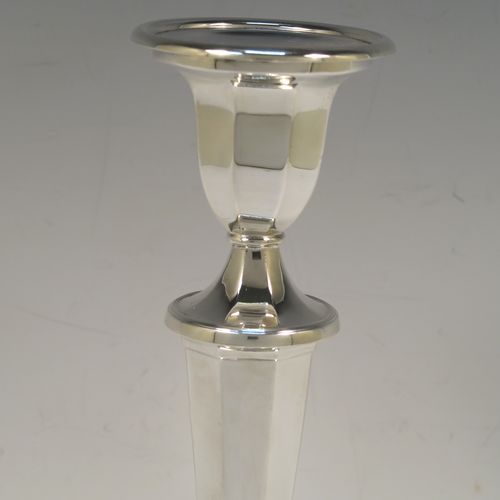A handsome Sterling Silver pair of candlesticks, having round and octagonal panelled style bodies, with reeded borders, and removable nozzles. These beautiful silver candlesticks were made by Roberts and Belk of Sheffield in 1968. The dimensions of these fine hand-made silver table candlesticks are height 25.5 cms (10 inches), and diameter at base 12 cms (4.75 inches).