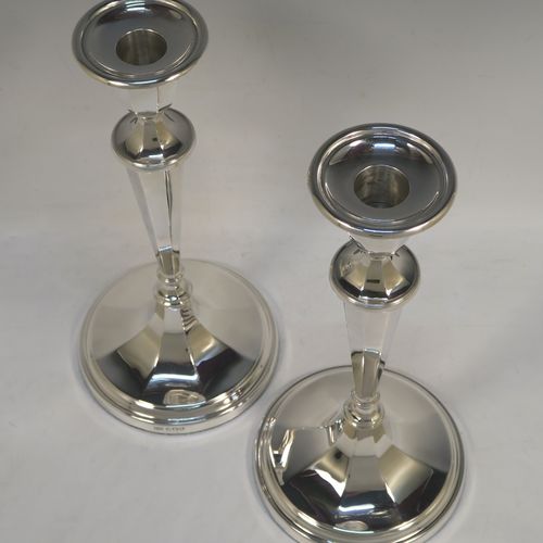 A handsome Sterling Silver pair of candlesticks, having round and octagonal panelled style bodies, with reeded borders, and removable nozzles. These beautiful silver candlesticks were made by Roberts and Belk of Sheffield in 1968. The dimensions of these fine hand-made silver table candlesticks are height 25.5 cms (10 inches), and diameter at base 12 cms (4.75 inches).