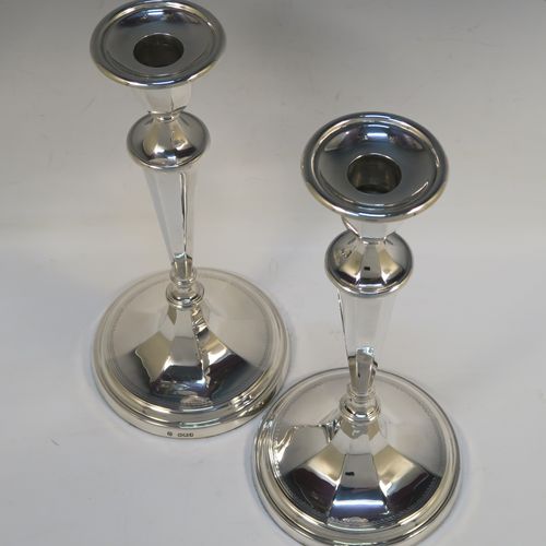 A very handsome pair of Antique Edwardian Sterling Silver candlesticks, having neoclassical round  octagonal panelled bodies with reeded borders and tapering columns, and original removable nozzles. These elegant antique silver candlesticks were made by Fordham and Faulkner of Sheffield in 1910. The dimensions of these fine hand-made antique silver candlesticks are height 25.5 cms (10 inches), and the bases are 12 cms (4.75 inches) in diameter.   