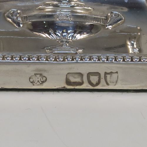 A very pretty pair of Antique Victorian Sterling Silver Neoclassical style candlesticks, having bead-edged borders, with hand-chased rams heads, swags, ribbons, and tureens, with removable nozzles, and square bases. These beautiful antique silver candlesticks were made by William Hutton and Sons of London in 1895. The dimensions of this fine hand-made pair of antique silver candlesticks are height 20 cms (8 inches), and the bases are 9 cms (3.5 inches) square.
