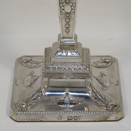 A very pretty pair of Antique Victorian Sterling Silver Neoclassical style candlesticks, having bead-edged borders, with hand-chased rams heads, swags, ribbons, and tureens, with removable nozzles, and square bases. These beautiful antique silver candlesticks were made by William Hutton and Sons of London in 1895. The dimensions of this fine hand-made pair of antique silver candlesticks are height 20 cms (8 inches), and the bases are 9 cms (3.5 inches) square.